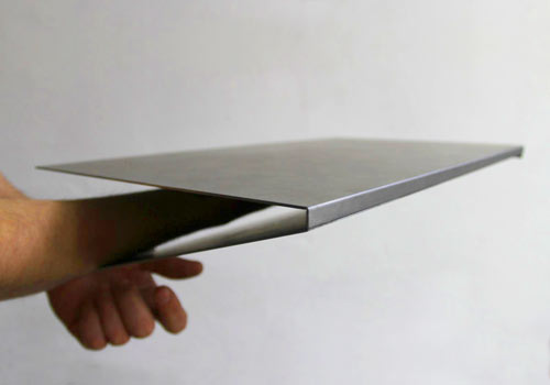 Custom bent metal edge profile for the Lictenstein Studio table